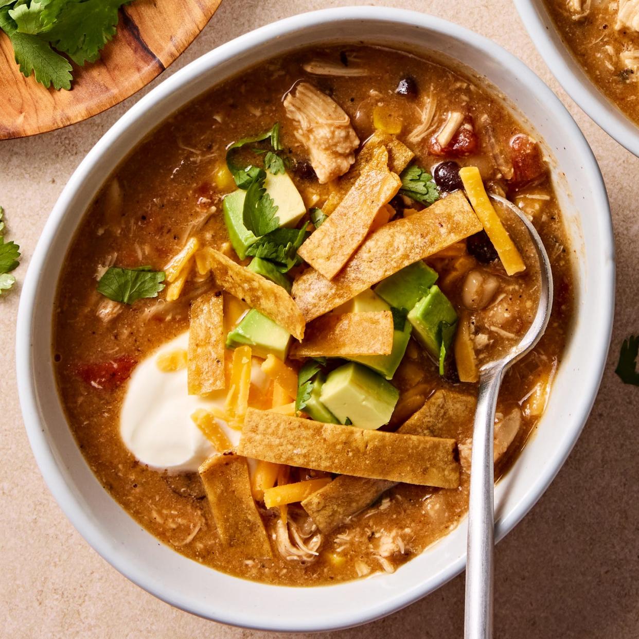 Copycat chickfila chicken tortilla soup made with tortilla strips, cilantro, avocado and sour cream.